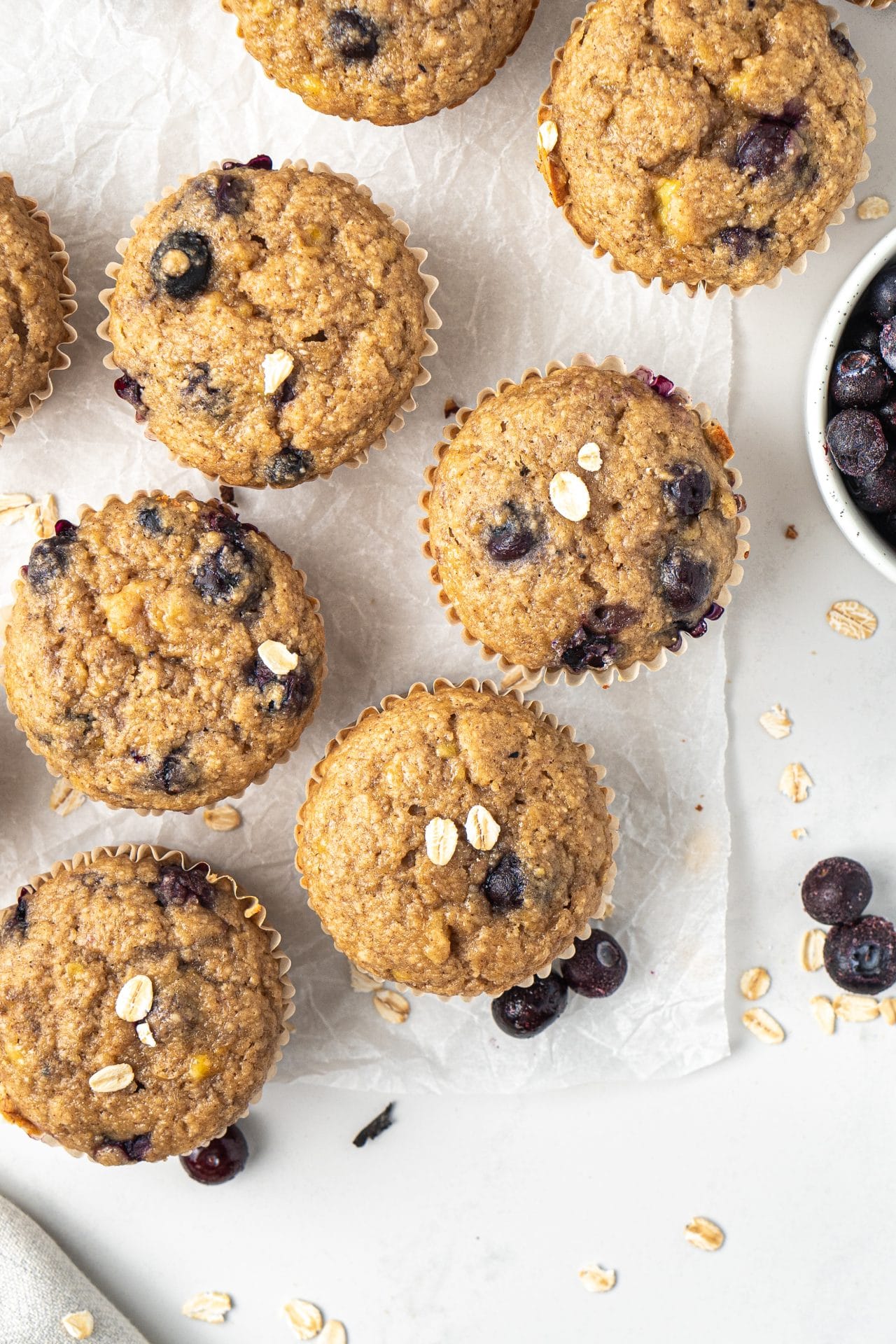Healthy banana blueberry oat muffins arranged on a white counter.